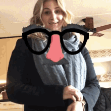 a woman wearing glasses and a fake nose is smiling