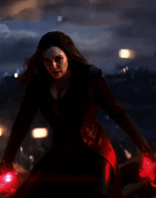 a woman in a red coat is holding a red light