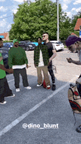 a group of people standing in a parking lot with the name dino blunt on the bottom right