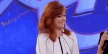a woman with red hair is talking into a microphone .
