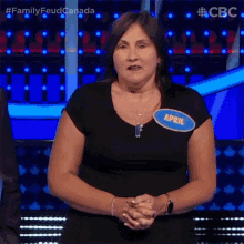 a woman wearing a black shirt with a name tag that says april on it