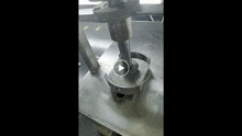 a close up of a metal object on a table with a brush on it