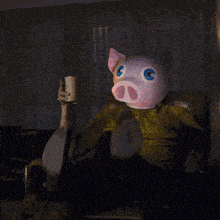 a person wearing a pig mask is sitting in a chair holding a cup