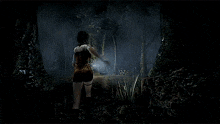 a woman is walking through a dark forest in a video game .