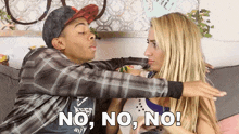 a man and a woman are sitting on a couch and the woman is saying no