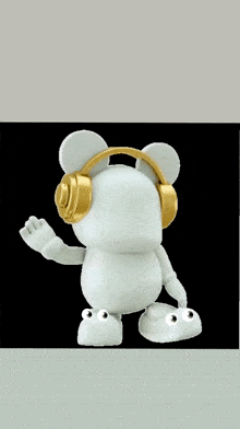 a white teddy bear wearing gold headphones with a black background