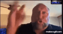 a man with a beard is making a funny face while looking at the camera .