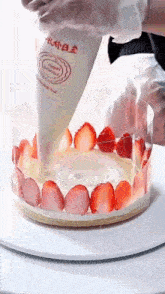 a person is frosting a cake with strawberries and cream