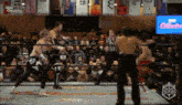 a group of men are wrestling in a ring with a referee .