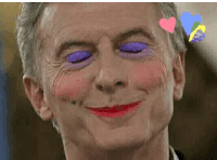 a close up of a man with purple eyes and red lipstick on his face