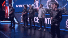 a group of men are standing in front of a screen that says vengeance