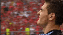 a close up of a man 's face with a crowd in the background .