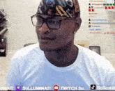 a man wearing glasses and a bandana is sitting in front of a twitch so banner
