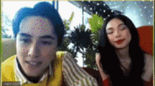 a man and a woman are sitting on a couch and smiling