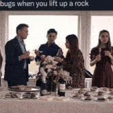 a group of people are gathered around a table with a caption that says bugs when you lift up a rock
