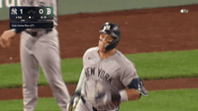 a baseball player for the new york yankees is running towards home plate