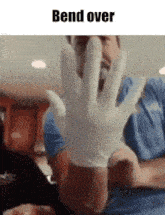 a man wearing a latex glove is bent over