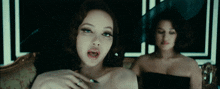 a woman with a ring on her finger looks at the camera