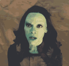 a close up of a woman 's face with green makeup