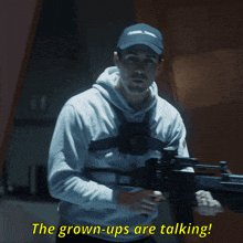 a man holding a gun with the words the grown-ups are talking