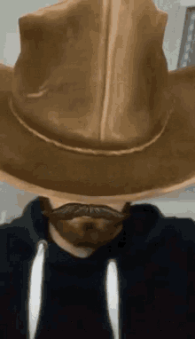 a man wearing a cowboy hat and mustache