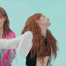 a woman with long red hair is looking up at something