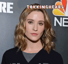 a woman stands in front of a sign that says nbc ne