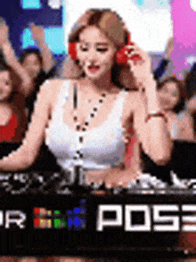 a woman wearing headphones is playing music on a dj 's deck at a party .