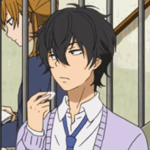 a boy in a purple sweater and blue tie is looking at something
