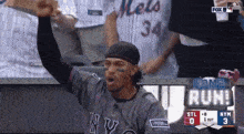 a man in a mets jersey holds up his fist in the air