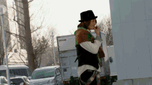 a man wearing a top hat is standing in front of a truck that says ' toyota ' on the side