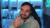 a man is giving a thumbs up in front of a neon sign that says one