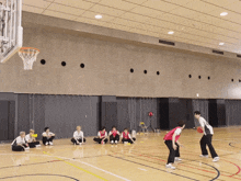 a group of people are playing basketball on a court with a man wearing a jersey that says ' basketball ' on it