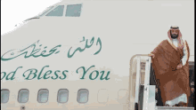 a man stands on the stairs of a plane that says " god bless you "