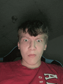 a young man wearing a red shirt that says ari on it