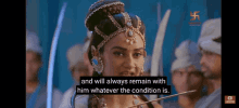 a woman is wearing a crown and holding a sword in front of a group of people .