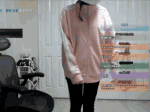 a woman in a pink jacket is standing in front of a chair and a door