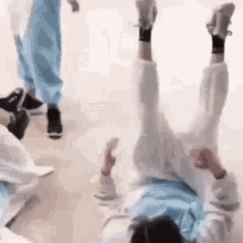 a person is laying on their back on a floor with their legs up .