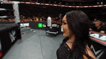 a woman in a wrestling ring with a bottle of gatorade in the background