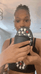 a woman is holding a remote control in her hand .