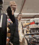 a man giving a thumbs down in a store