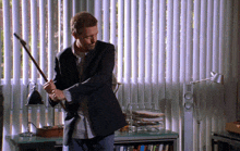 a man in a suit is holding a bat in his hand