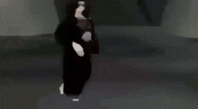 a person in a black coat is walking down a dark street .
