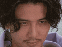 a close up of a man 's face with a beard and long hair