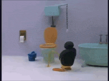 a penguin is sitting on a toilet in a bathroom next to a bathtub .