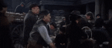 a group of men are standing around talking to each other .
