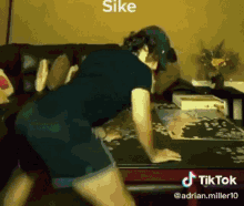 a man is doing push ups on a table with tiktok written on the bottom of the screen