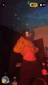 a man in a hoodie is dancing with his arms outstretched in front of a glowing ceiling with the number 10 on it