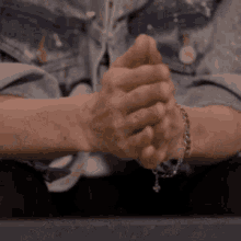 a close up of a person 's hands with a bracelet on their wrists .