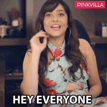a woman in a blue floral dress says " hey everyone "